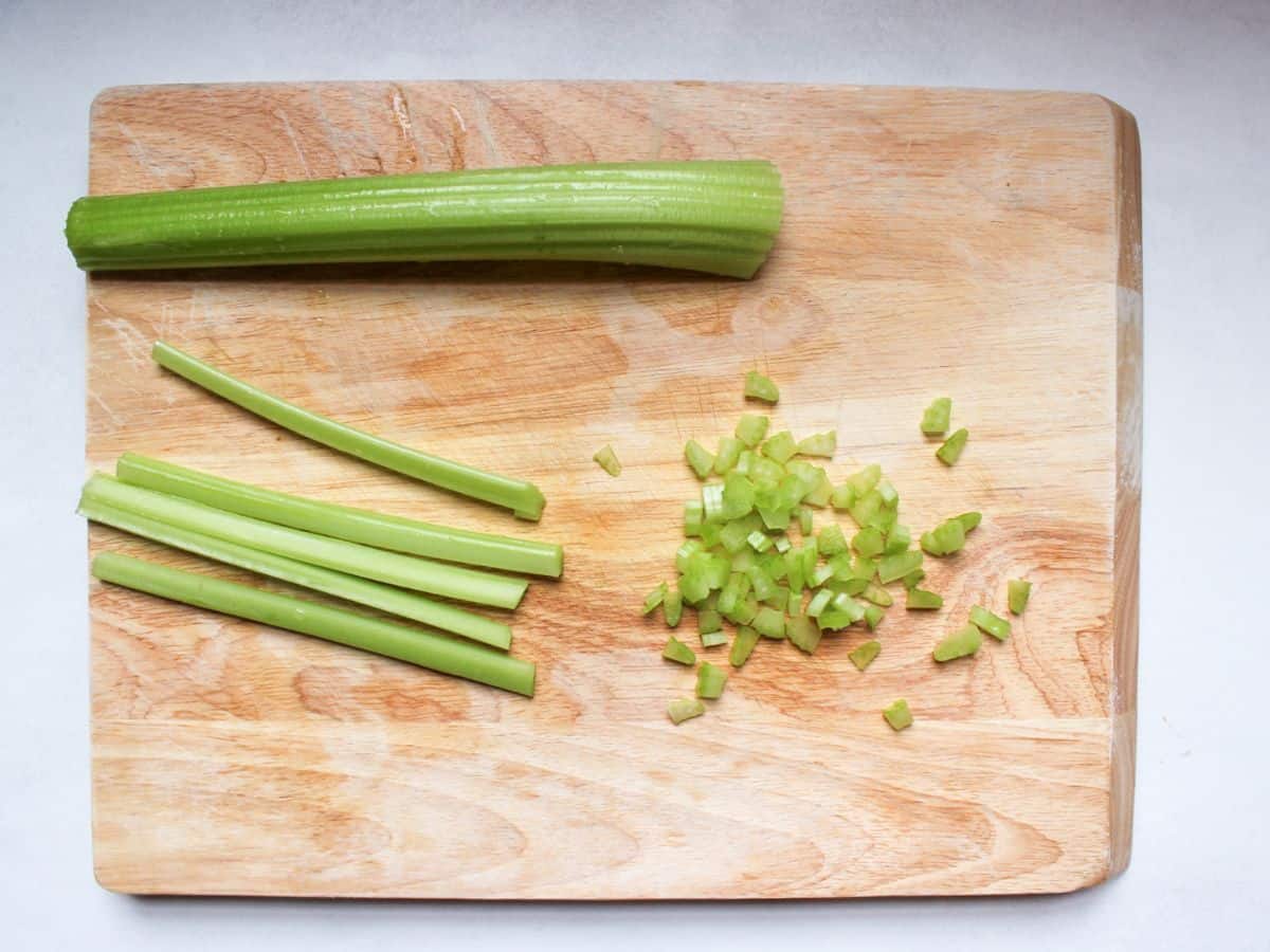 One whole celery rib and one rib is sliced lengthwise into 5 long pieces and diced into small cubes.