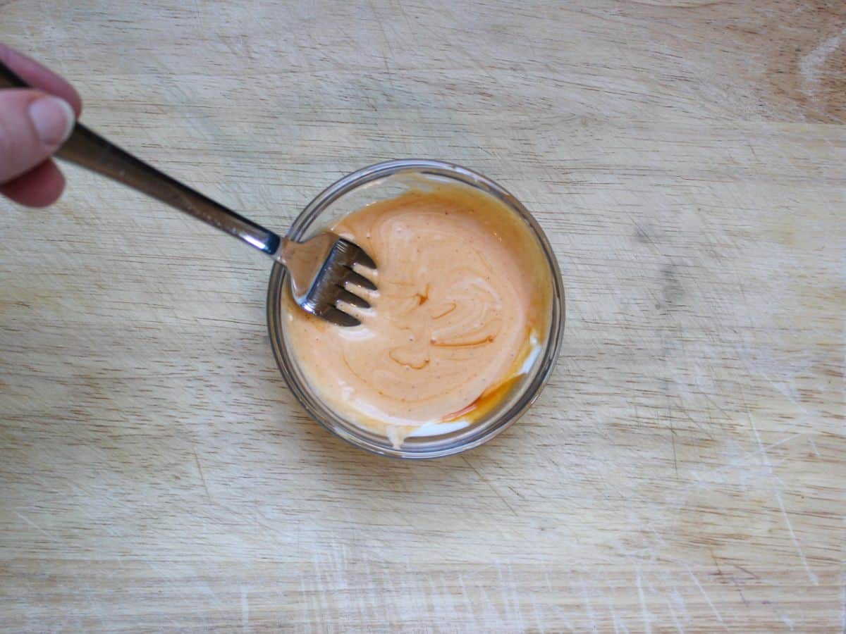 Buffalo blue cheese dressing in a small glass bowl with a fork in it.